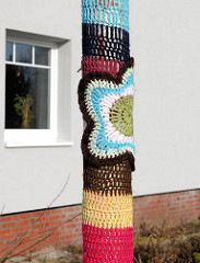 Detail eingestrickter Laternenmast in Uetersen - Guerilla Knitting, Urban Knitting - Kunst im öffentlichen Raum.