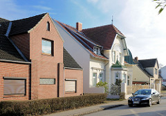 Unterschiedliche Architekturstile - Wohnhäuser in Uetersen; Jugendstilvilla und Wohnhaus mit Klinkerfassade - geschlossene Jalousie vor dem Fenster.