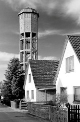 Wasserturm in Uetersen - Einzelhäuser mit Spitzdach; der 1926 errichtete 39m hohe Wasserturm steht unter Denkmalschutz - zylindrischer Wasserbehälter mit Ziegelmauerwerk verkleidet - Stahlbeton-Skelettkonstruktion.