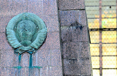 Bronzerelief sowjetisches Staatswappen - Ehrenmal für sowjetische Soldaten / Neuer Markt, Hansestadt Stralsund - errichtet 1967. Im Hintergrund Kirchenfenster der St. Marienkirche.