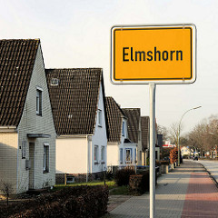 Ortschild Elmshorn - Einfamilienhäuser mit Spitzdach.