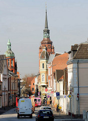 Strasse mit Wohngebäude / Geschäftshäusern in Itzehoe - Kirchturm der St. Laurentii Kirche.