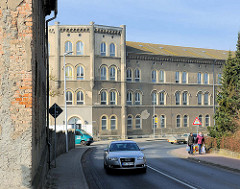 Historisches Kasernengebäude / Westkaserne des 9. Ulanenregiments / ehem. Kreiskrankenhaus der Hansestadt Demmin; Mauer mit abbröckelnden Putz, Ziegelsteine.