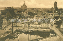 Historische Luftansicht vom Hafen der Hansestadt Stralsund  - Segelschiffe an der Kaimauer; lks. die Heiliggeistkirche; re. davon die St. Marienkirche und re. der Kirchturm der St. Jakobi Kirche.