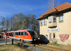 Schrankenhäuschen Bad Doberan - roter REGIO Zug der Deutschen Bahn.