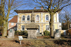 Sogen. Neunerdenkmal in Itzehoe - Ehren und Mahnmal für die im 1. Weltkrieg gefallenen 378 Soldaten des Feldartellerieregiments Nr. 9. Im Hintergrund das Probstenhaus / Hauptpastorat.