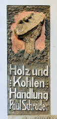 Fassadenbeschriftung Holz und Kohlen Handlung - Hand mit Brikett / Fotos aus der Hansestadt Stralsund.