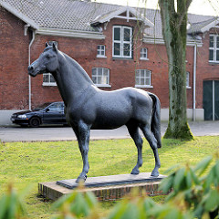 Lebensgrosse Bronzestatue vom erfolgreichen Holsteinerhengst Landgraf vor dem Gebäude der Reit- und Fahrschule Elmshorn.