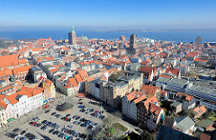 Blick auf die Hansestadt Stralsund - Luftaufnahme; im Vordergrund der Neue Markt - re. die Kirche St. Jacobi und die Speichergebäude am Stralsunder Hafen - lks. der Kirchturm der St. Nikoliakirche.