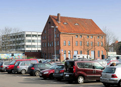 Blick über den Parkplatz Buttermarkt zur historischen Backsteinarchitektur der ehemaligen Markthalle in Elmshorn - das Gebäude war auch Teil der ehem. dort ansässigen Lederfabrik.
