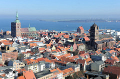 Kirchtürme der Hansestadt Stralsund - lks. die Pfarrkirche St. Nikolai, re. die St. Jacobikirche; im Hintergrund der Strelasund / Meerenge der Ostsee.