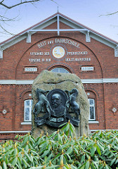 Denkmal Georg Ahsbahs vor der Fassade der Reit- und Fahrschule Elmshorn - Ahsbahs vereinigte 1891 die verschiedenen Pferdezüchtervereine zum Verband der der Pferdezuchtvereine in den Holsteinischen Marschen.