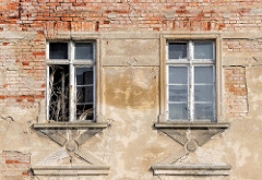 Fassade einer verfallenen Gewerbeimmobilie in der Hansestadt Demmin - abbröckelnder Putz, Ziegelsteine - verrottete Fenster.