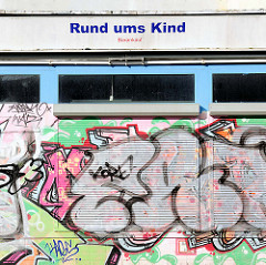 Geschäft mit heruntergelassenen Rollläden - bunte Graffiti / Laden in Rostock Lichtenhagen - Rund ums Kind, Barkauf.