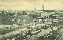 Historische Ansicht vom Hafen und der Stadt Elmshorn ca. 1919; das Ufer der Krückau ist dicht mit einer Flotte von Ewern belegt - im Hintergrund der Turm der St. Nikolaikirche.