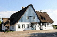 Restaurant / Cafegarten in Neuendorf - Reetdachgebäude; hellblau und weiss gestrichener Holzgiebel.