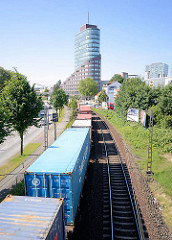 Güterzug mit Containern in Harburg entlang der Buxtehuder Strasse - im Hintergrund der Channel Tower am Stadtentwicklungsprojekt Channel in Harburg.