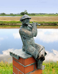 Bronzefigur mit Musikinstrument an der Wasserpromenade von Wittenberge - Skulpturengruppe Zeitreise / Künstler Christian Uhlig.