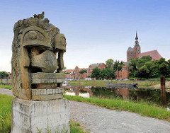 Skulptur an der Elbpromenade in Tangemünde - im Hintergrund die St. Stephanskirche