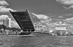 Bürogebäude Dockland am Ufer der Elbe im Hamburger Stadtteil Altona Altstadt - im Hintergrund das Kreuzfahrtschiff MSC MAGNIFICA.