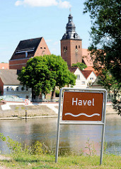 Blick über die Havel zur Stadtkirche St. Laurentius; Schild Flussname Havel.