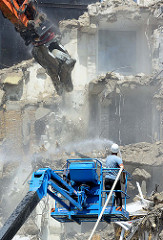 Abriss der Esso-Häuser auf Hamburg St. Pauli. Ein Arbeiter auf einer Hebebühne spritzt mit einem Schlauch Wasser auf die herabfallenden Haustrümmer.