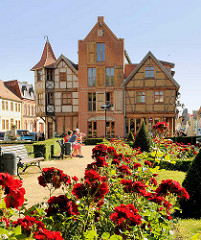 Historische Architektur in Tangermünde  - Rosengarten mit blühenden Rosen; Gebäude  Erlebnishotel Exempel Schlafstuben.