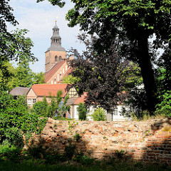 Alte Mauer in den Wallanlagen der Hansestadt Gardelegen - zwischen den Bäumen der Kirchturm der Marienkirche; Backsteingotik - Ursprungsbau aus dem 12. Jahrhundert.