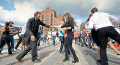 Veranstaltung Swing Tanzen in der Hamburger Hafencity - im Hintergrund des Gebäude des Kaispeichers B, das Maritime Museum am Magdeburger Hafen.