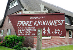 Hinweisschild in Seestermühe - Historische Fähre Kronsnest mit Öffnungszeiten.