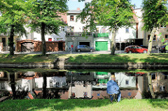 Angler mit Stohhut an der Stepenitz in Perleberg - Wohnhäuser am Fluss.