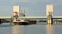 Ein Binnenschiff fährt von der Norderelbe durch das Sperrwerk in die Billwerder Bucht von Hamburg Rothenbursort.