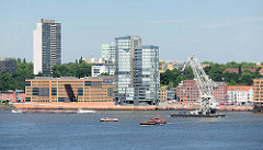 Bürohäuser am Elbufer Grosse Elbstrasse in Hamburg Altona / Altstadt; ein Schwimmkran fährt Richtung Hafen.