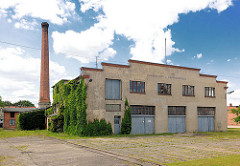 Einfache Gewerbearchitektur - schlichte Putzfassade, Garagentor - Fabrikschornstein; Architekturbilder aus Perleberg.
