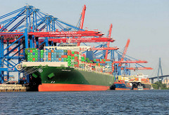 Das 368 m lange Containerschiff / Container Vessel THALASSA ELPIDA unter den Containerbrücken vom Terminal Burchardkai. Das 2014 gebaute Frachtschiff kann 13808 TEU Container transportieren.