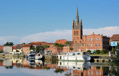 Stadthafen von Grabow an der Elde am Abend - Sportboote haben als Gastlieger an der Kaimauer angelegt - Kirchturm der St. Georg Kirche.