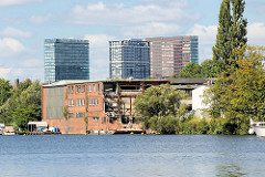 Ein altes Gewerbegebäude am Ufer der Bille in Hamburg Hammberbrook wird abgerissen - - im Hintergrund die Hochhäuser am Berliner Tor.