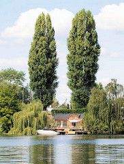 Schrebergarten, Kleingarten am Ufer der Bille in Hamburg Rothenburgsort - Sportboot am Anleger, hohe Pappeln.