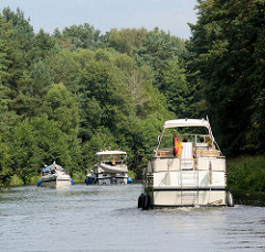 Sportboote, Motorboote zwischen Bäumen auf dem Elde Müritz Kanal.