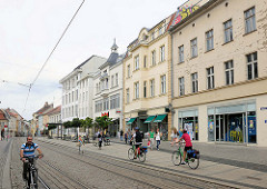 Geschäftshäuser in der Hauptstrasse von Brandneburg an der Havel. Geschäfte und FahrradfahrerInnen.