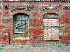 Verlassenes Backsteingebäude, Ziegelfassade - Fensteröffnungen, zugemauert + mit Holztür verschlossen - Fotos aus Grabow.
