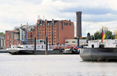 Binnenschiffe an ihren Liegeplätzen in der Billwerder Bucht in Hamburg Rothenburgsort - im Hintergrund der Wasserturm / Wasserspiele von Hamburg Rothenburgsort und die Industriearchitektur am Ausschläger Elbdeich