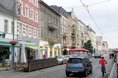 Geschäfte und Wohnhäuser in der Steinstrasse von Brandenburg a. d. Havel - Autoverkehr, Fahrradfahrer.