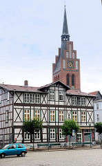 Historisches Wohnhaus / Geschäftshaus am Pferdemarkt in Grabow  - Fachwerhaus; Kirchturm der Kirche St. Georg.