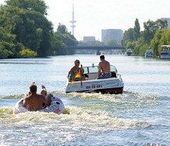 Motorboot mit Schlauchboot auf dem Bullenhuser Kanal in Hamburg Rothenburgsort - im Hintergrund der Fernsehturm der Hansestadt.