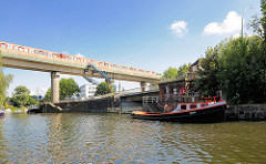 Eisenbahnbrücke in Hamburg Rothenburgsort über den Billhornfer Kanal; Liegeplatz für Sportboote. Im Vordergrund die Bille kurz vor der Brandshofer Schleuse - Barkasse Ursula am Kai.