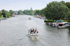 Blick auf die Brandenburgische Havel - ein Sportboot fährt Richtung Stadt Brandenburg an der Havel - Sportboote, Motorboote liegen am Ufer.
