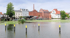 Blick über den Stadtkanal zu Backsteinarchitektur / Industriearchitektur und Wohnhäusern am Mühlendamm in Brandenburg an der Havel.