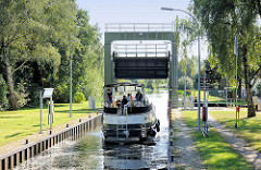 Schleuse vom Elde-Müritz-Wasserweg in Parchim; das Signallicht zeigt Grün, ein Sportboot verlässt die Schleusenkammer.