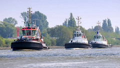 Drei Schlepper / Arbeitsschiffe in Fahrt auf dem Reiherstieg in Hamburg Wilhelmsburg.